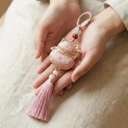 Pink Lucky Cat Fortune Knot Tassel Charm — hand-held size reference