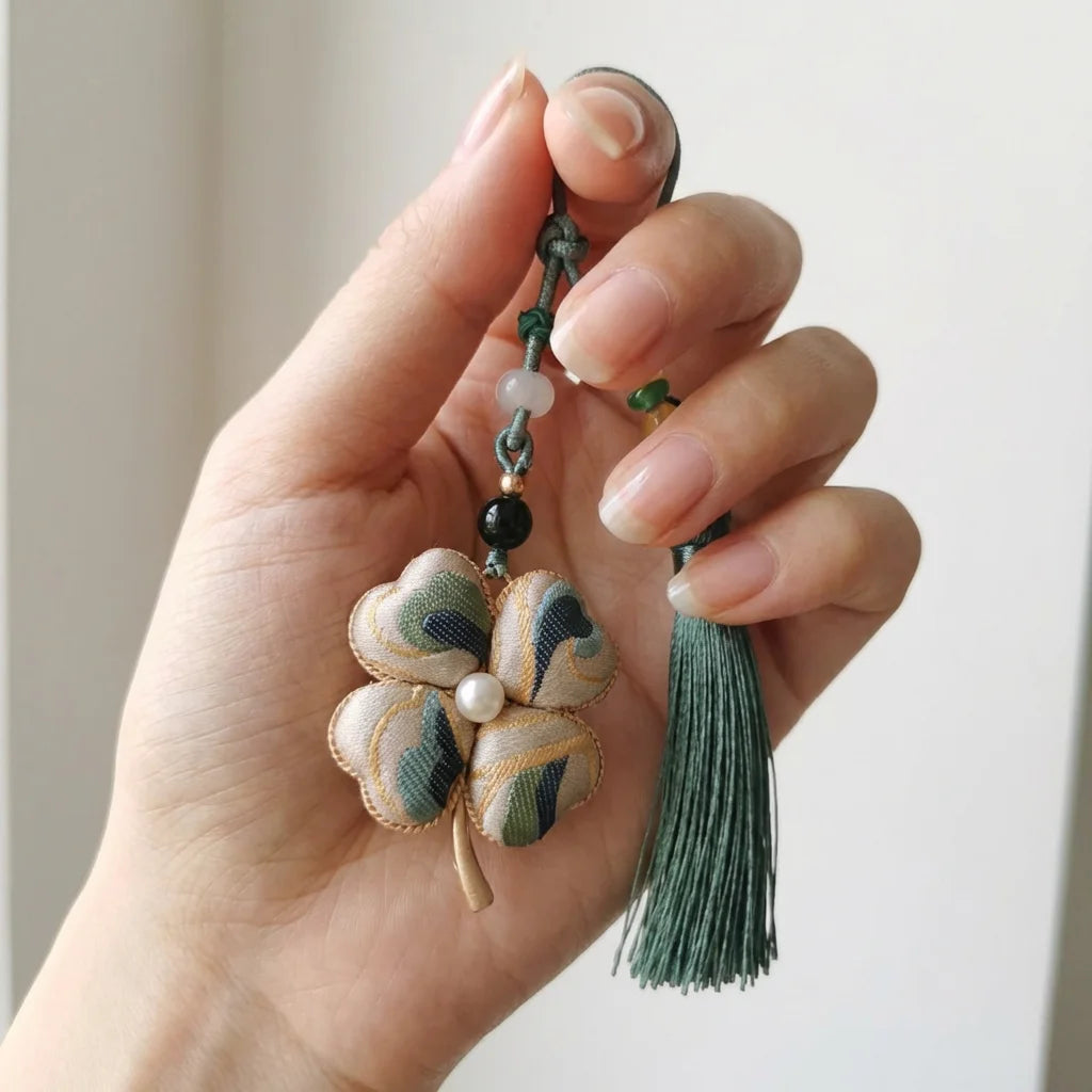 Clover Silk Brocade Phone Charm — Sage Blue held in fingertips SIZE scale reference