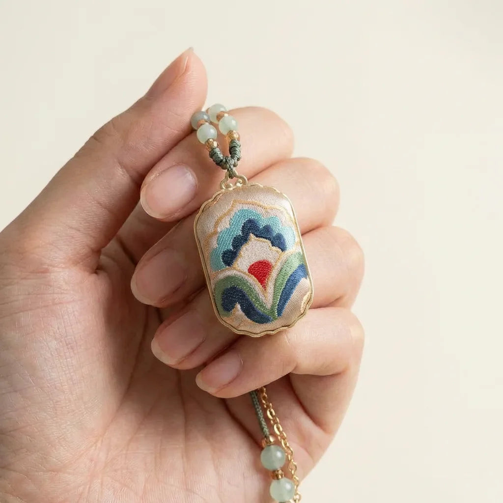 Shu Brocade Rectangular Pendant Necklace — Cloud Motif held in fingertips elegant SIZE scale reference