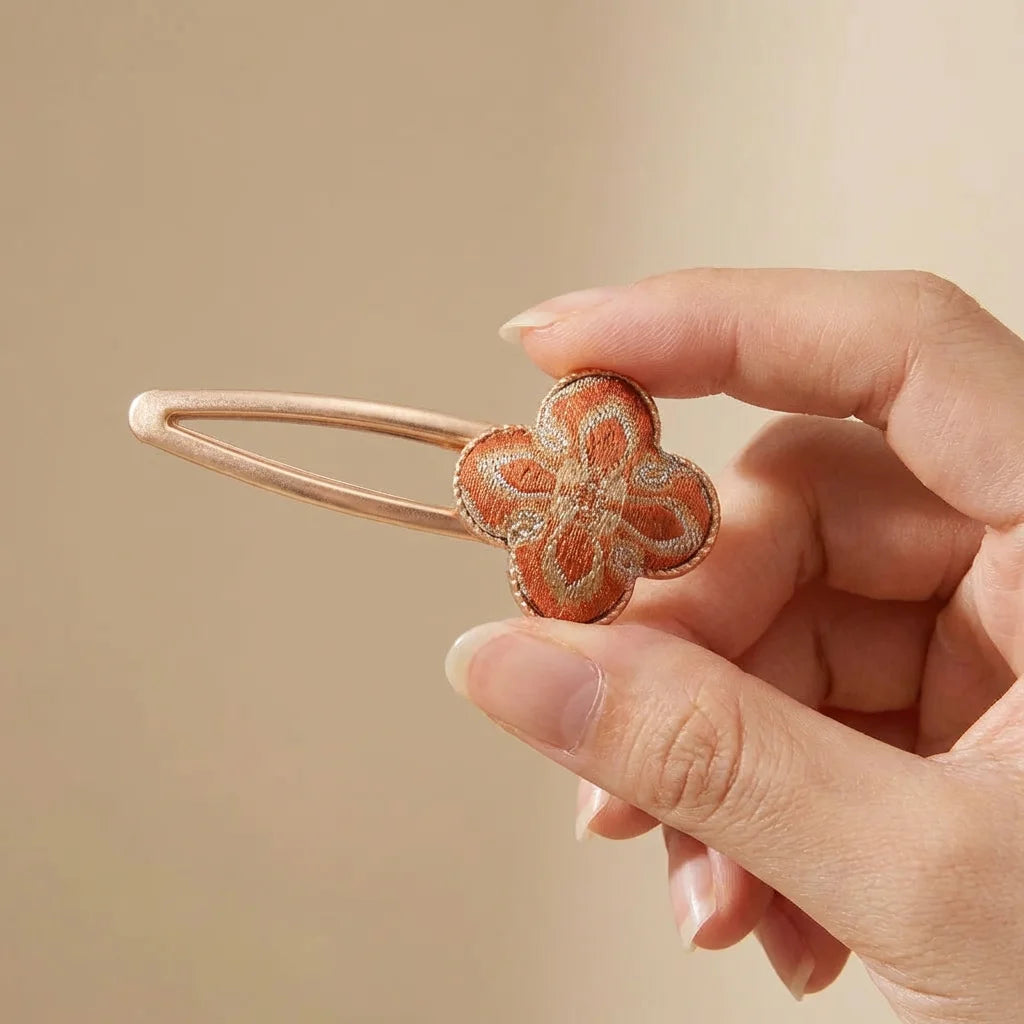 Clover Silk Brocade Snap Hair Clip — Terracotta held in hand SIZE scale reference